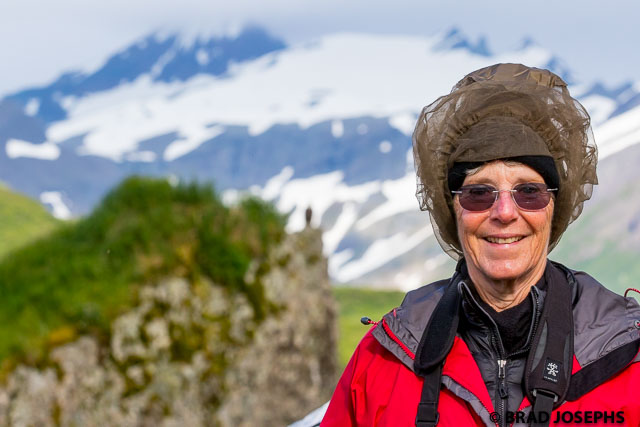Longtime Nathab traveler Tish Beach with volcanos, glaciers and an eagle's nest behind. 